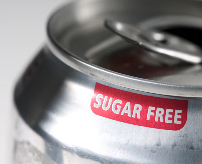 A close-up of a sugar-free soda can with a red label, emphasizing the role of blood sugar control supplements in dietary choices.